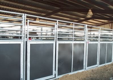 A horse is standing in a fenced in area in a barn.