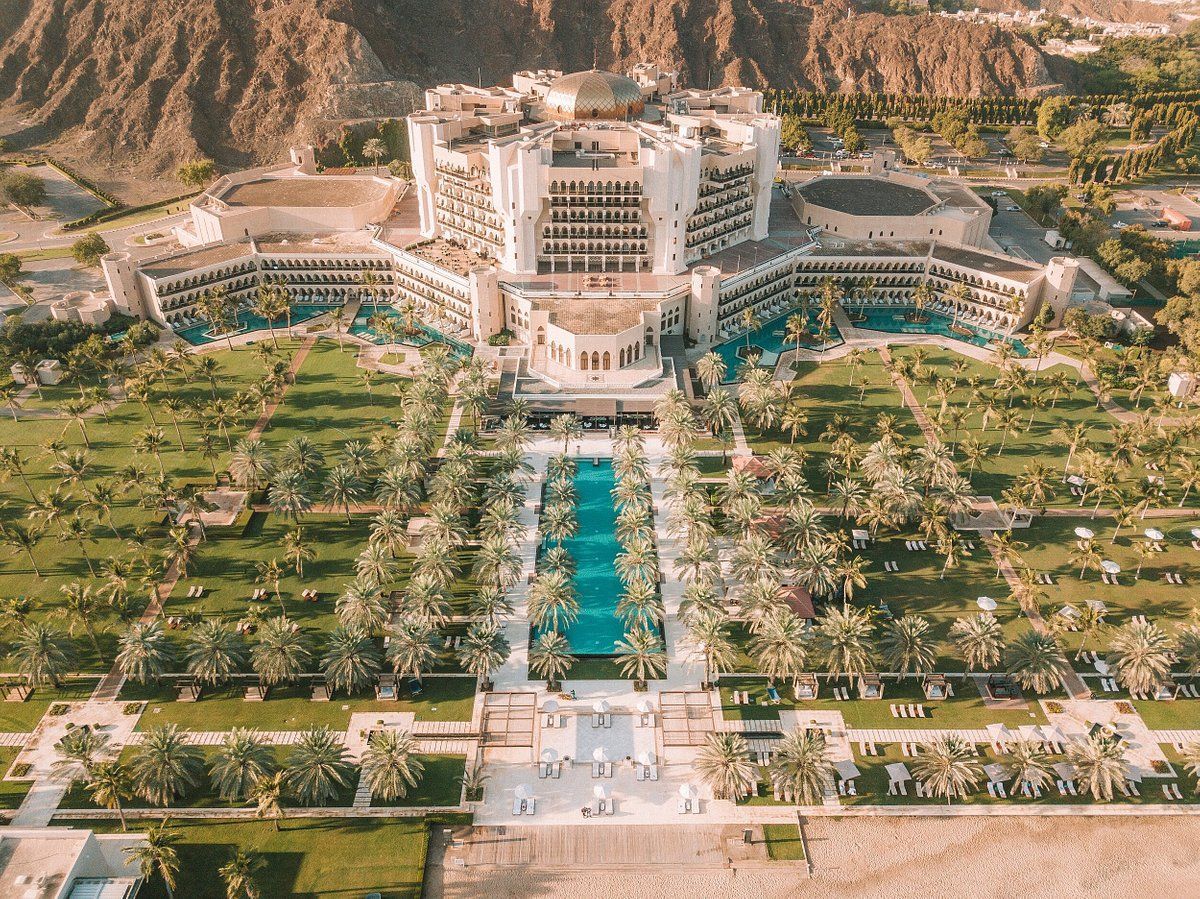 An aerial view of a large hotel surrounded by trees and mountains.