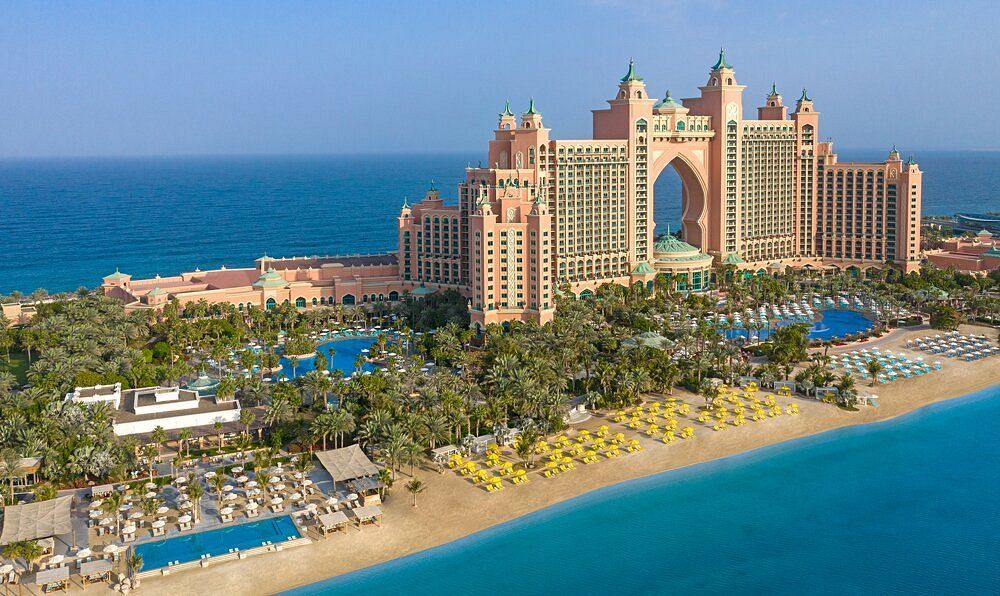 An aerial view of a large building on a beach next to the ocean.