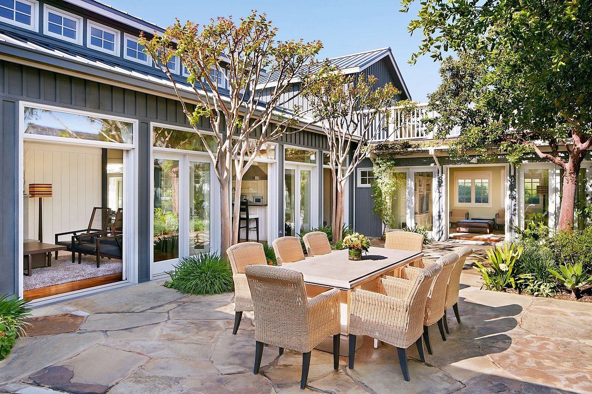 A patio with a table and chairs in front of a house.