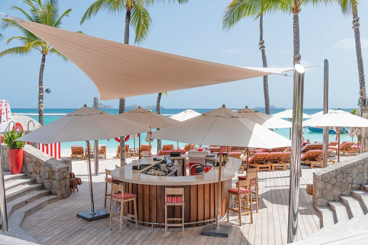 A bar on a beach with umbrellas and chairs