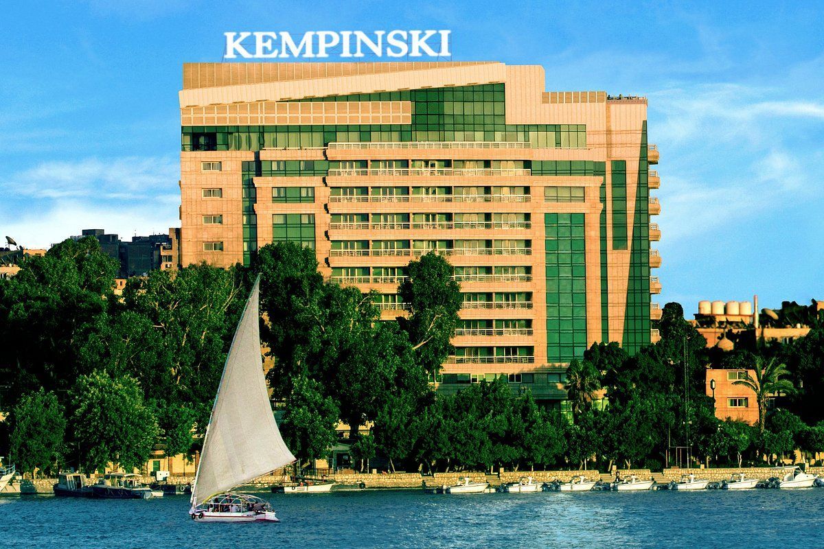 A sailboat is in front of a kempinski building