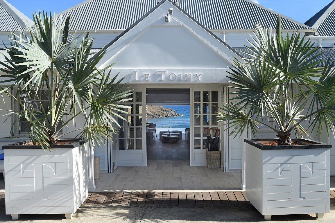 A white building with palm trees in front of it