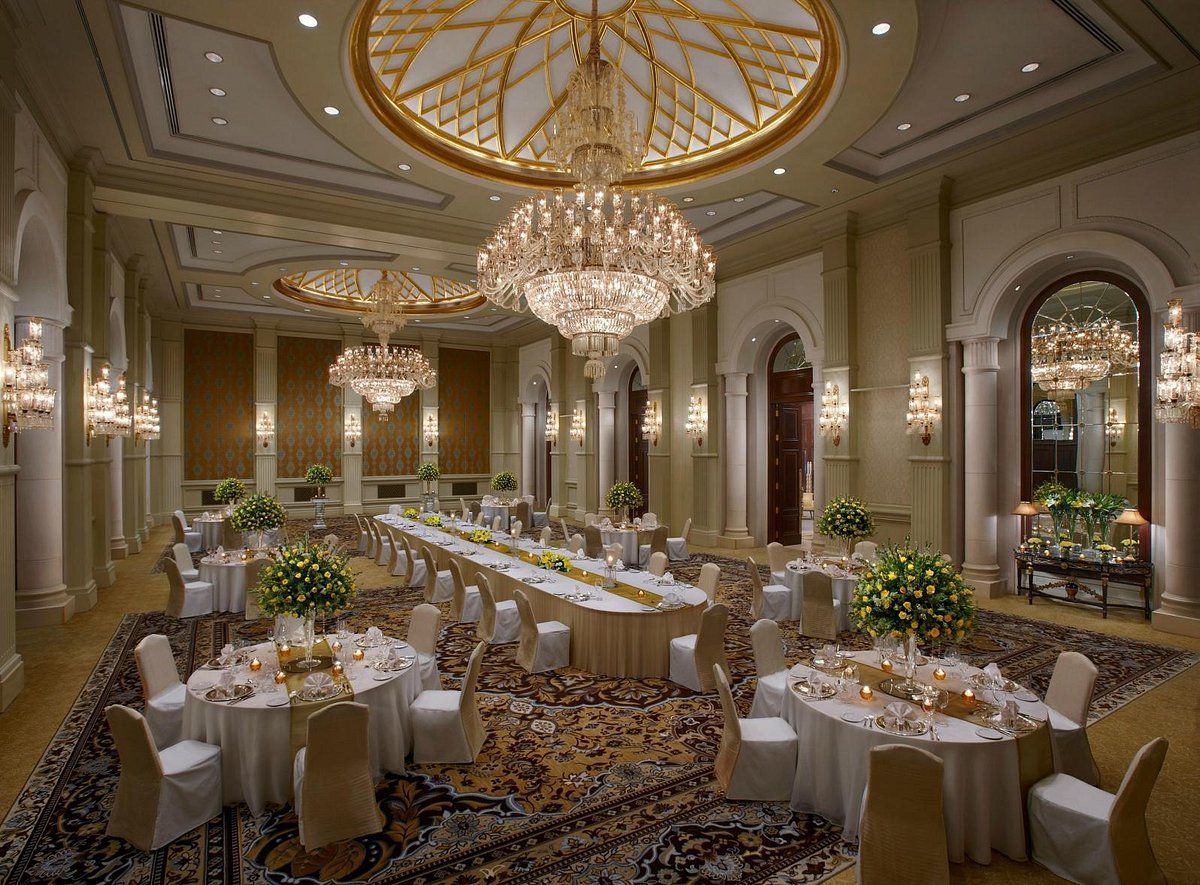 A large room with tables and chairs and a chandelier.