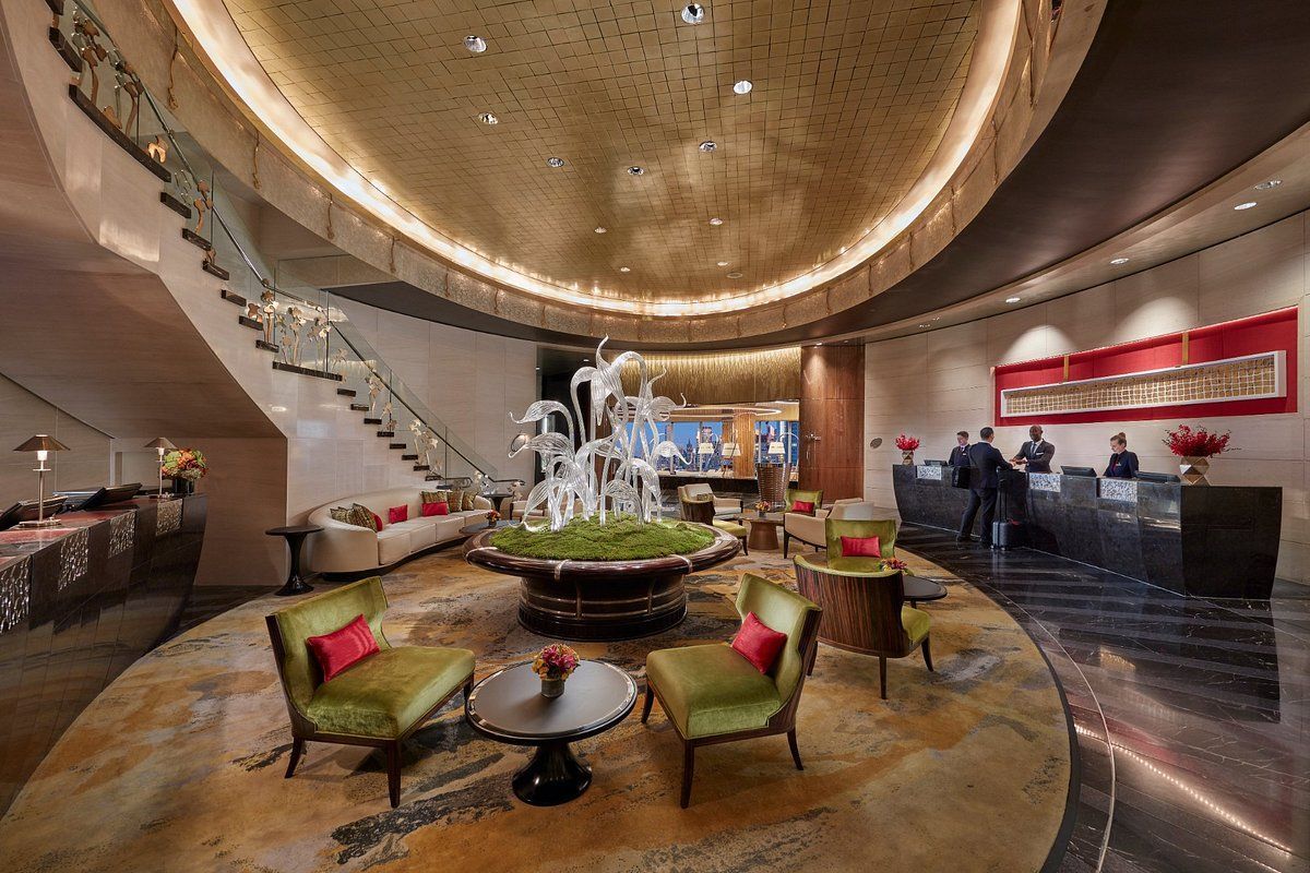 A large lobby of a hotel with a fountain in the middle.