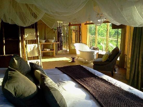 A bedroom with a canopy bed and a bathtub