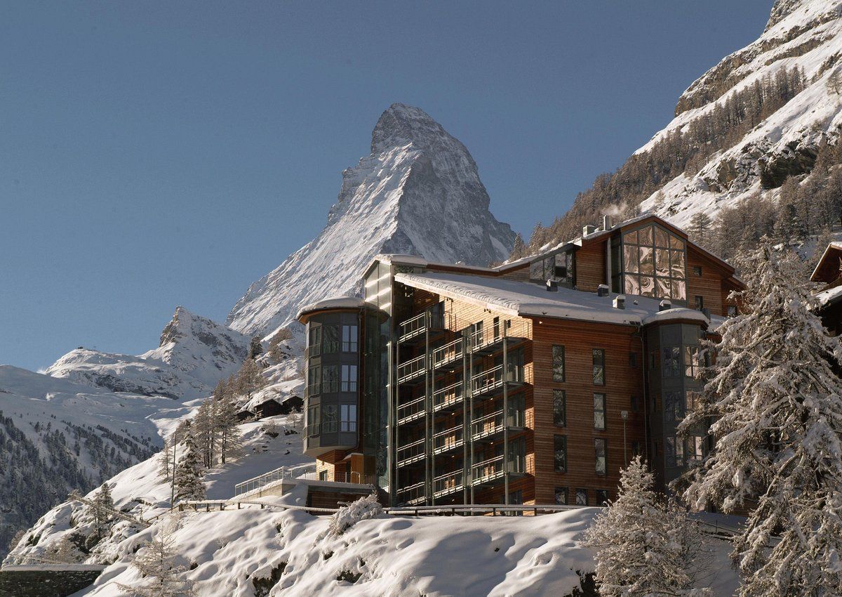 A snowy mountain with a building in the foreground