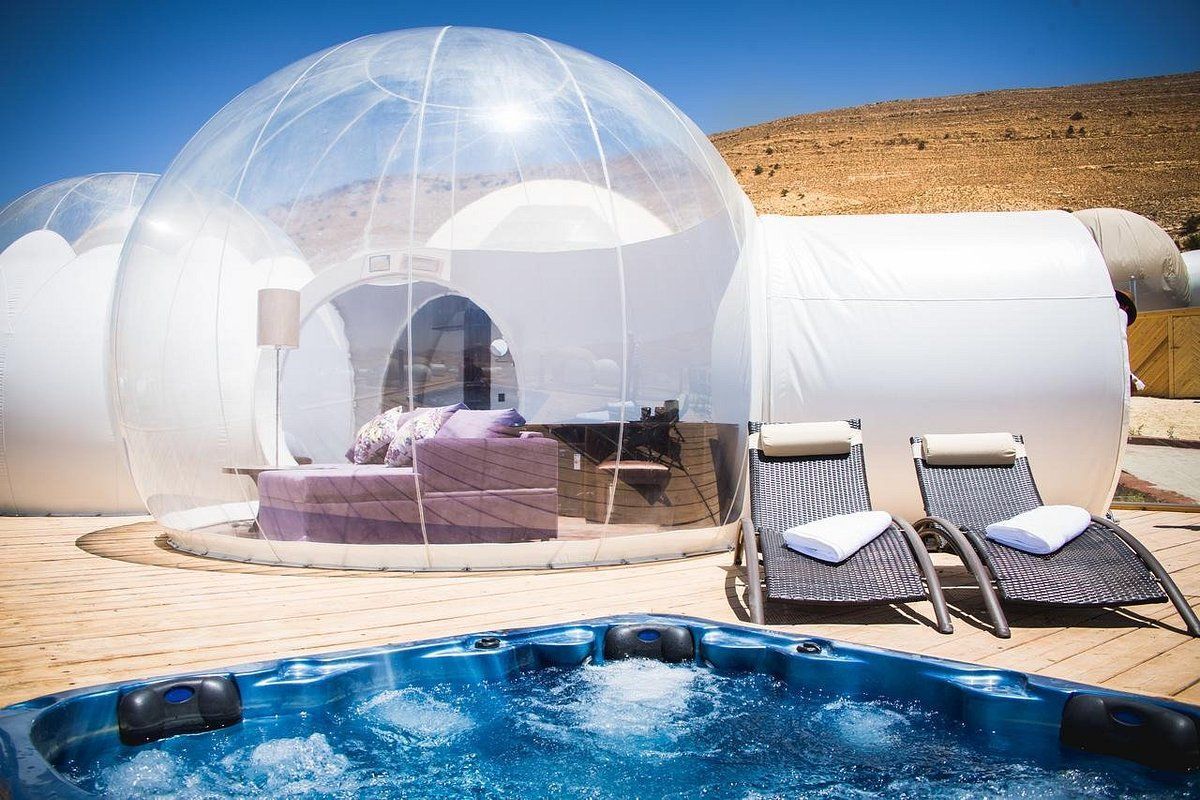 There is a hot tub in front of a bubble tent.