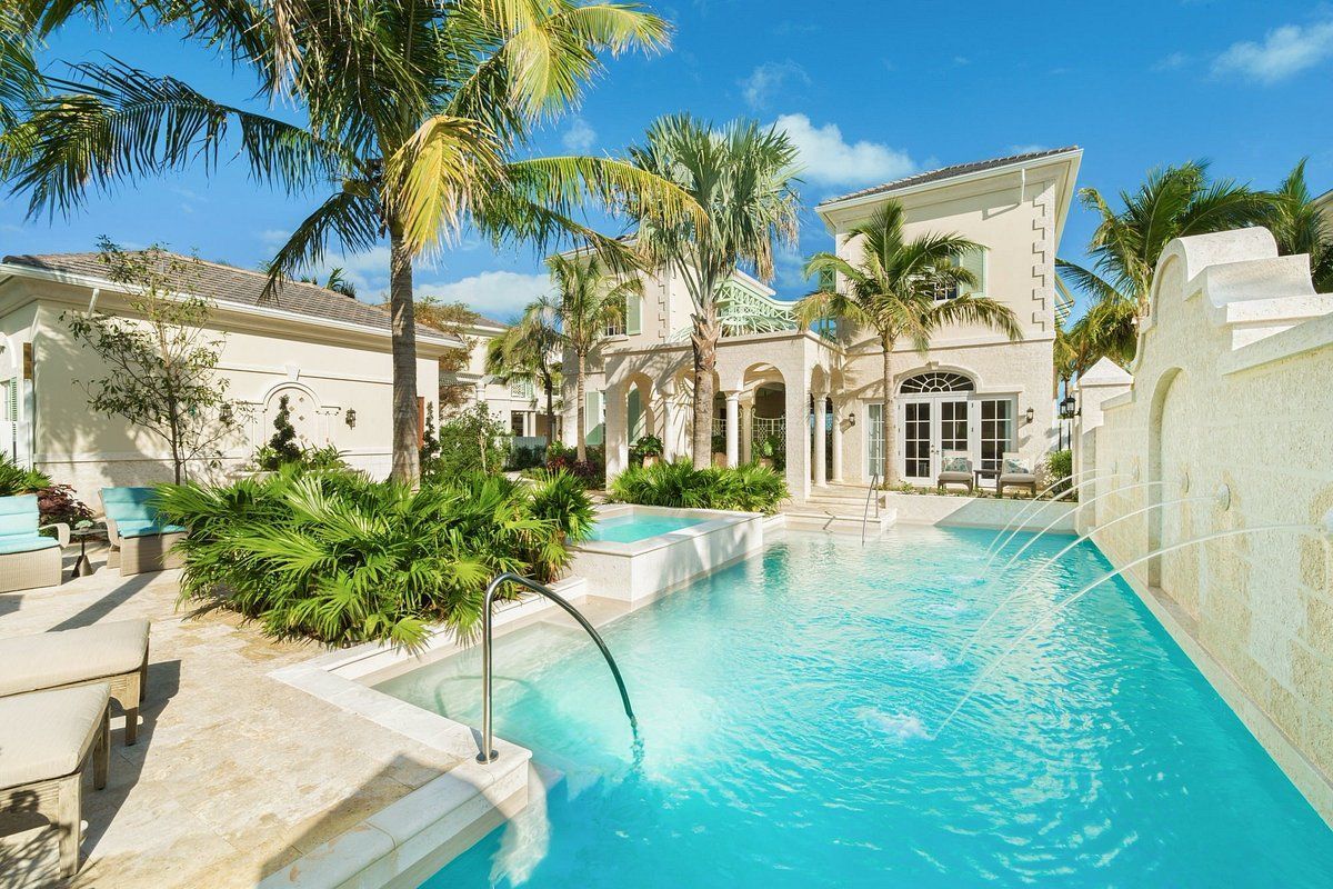 A large house with a swimming pool in front of it
