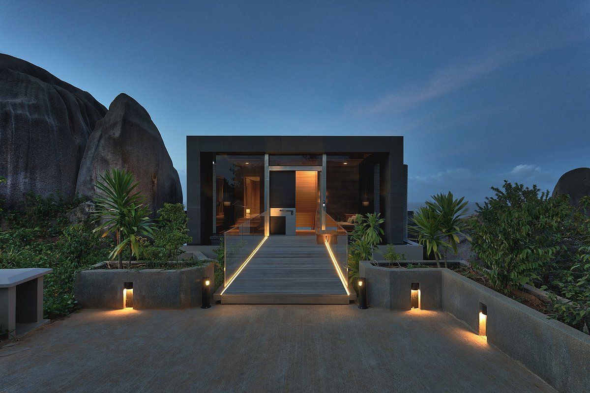 A modern house with a large rock in the background