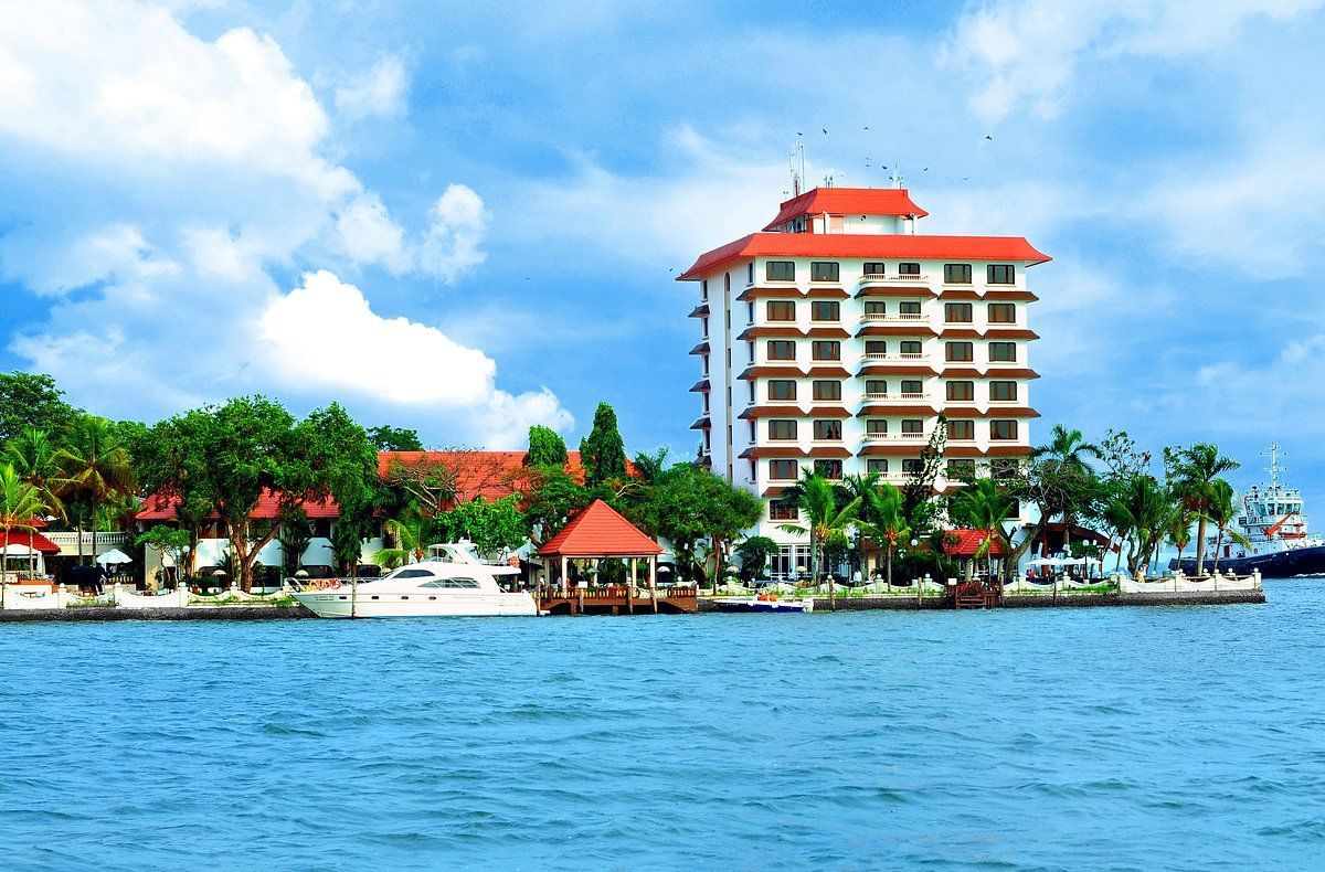 A large building sits on the shore of a body of water