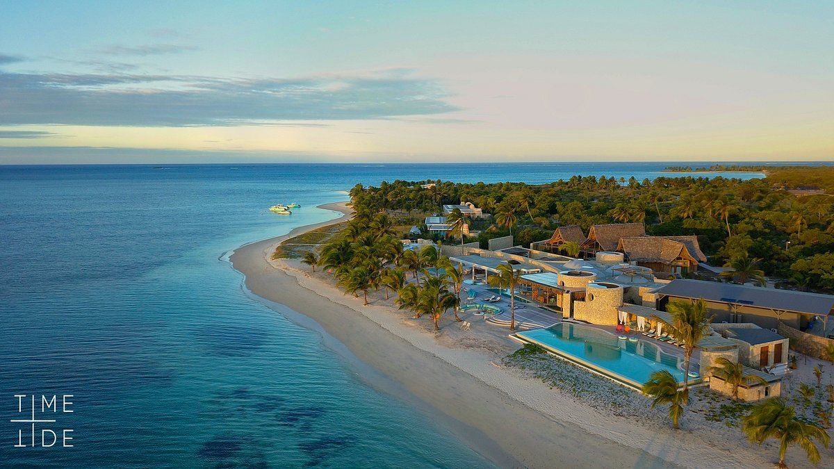 An aerial view of a resort on a small island in the middle of the ocean.