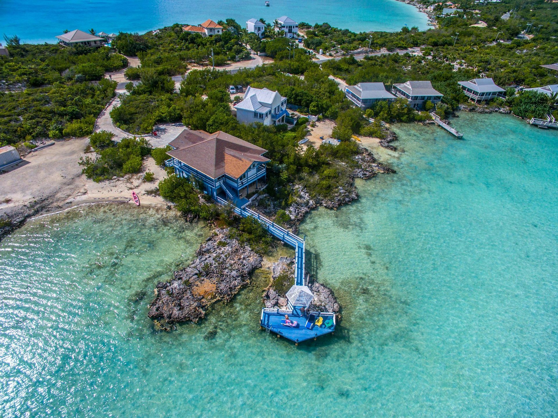 An aerial view of a house on a small island in the middle of the ocean.