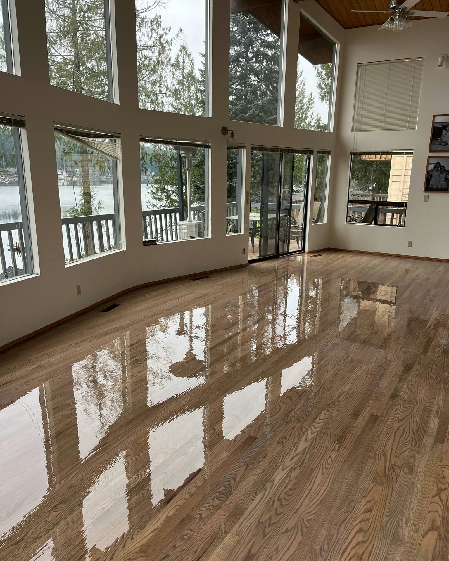 A large room with hardwood floors and lots of windows