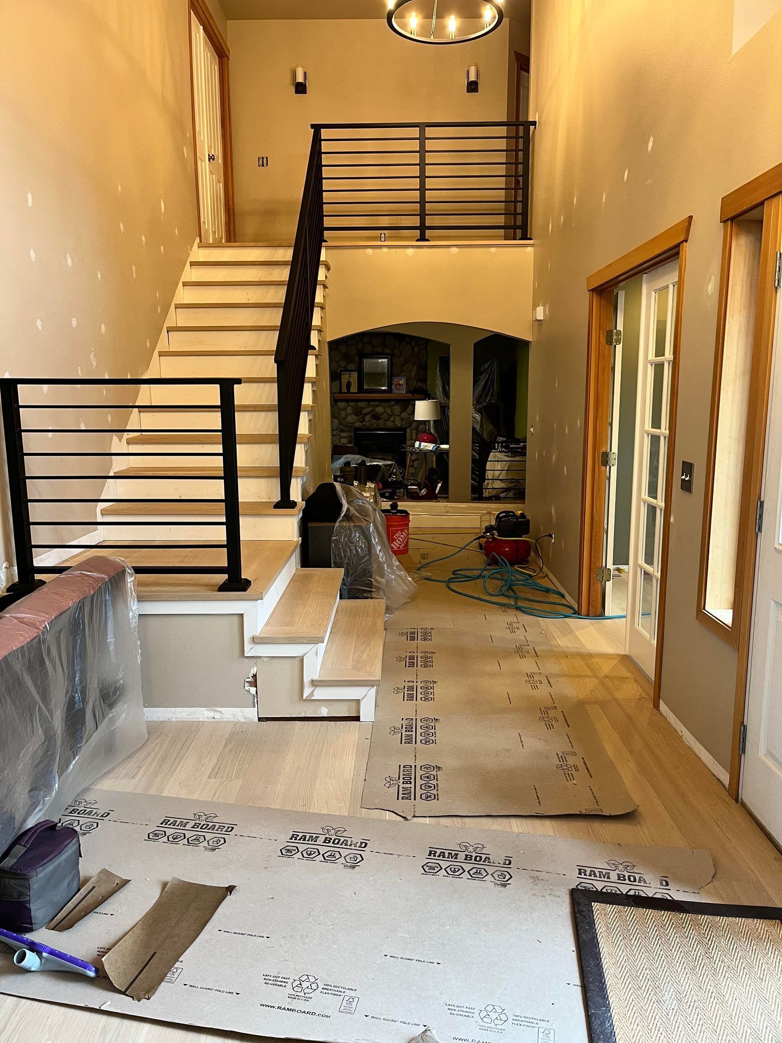 A hallway with a staircase and a rug on the floor.