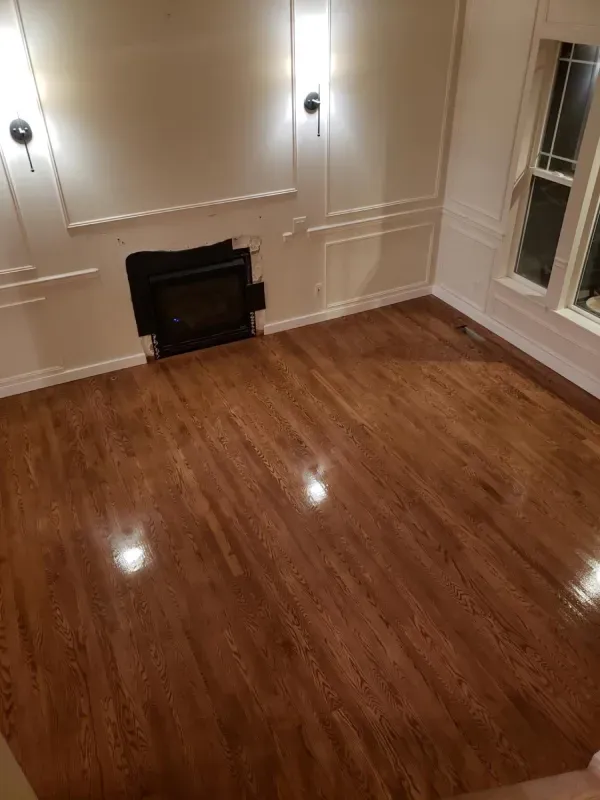 A living room with hardwood floors and a fireplace.