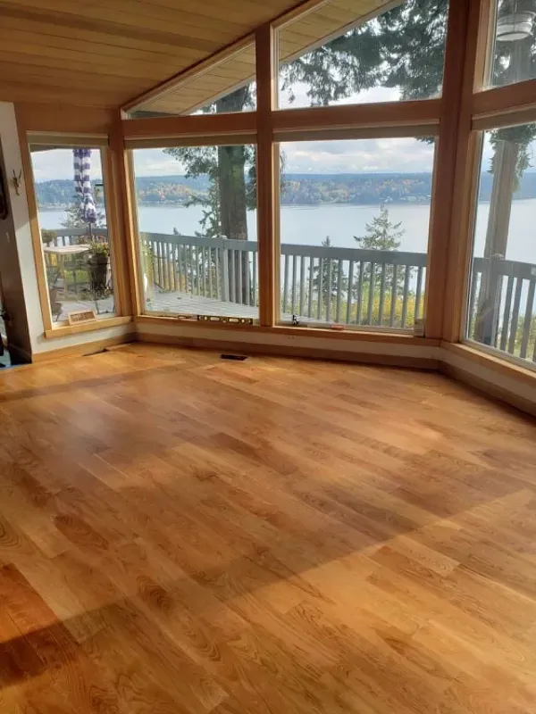 A large room with lots of windows and a view of a lake