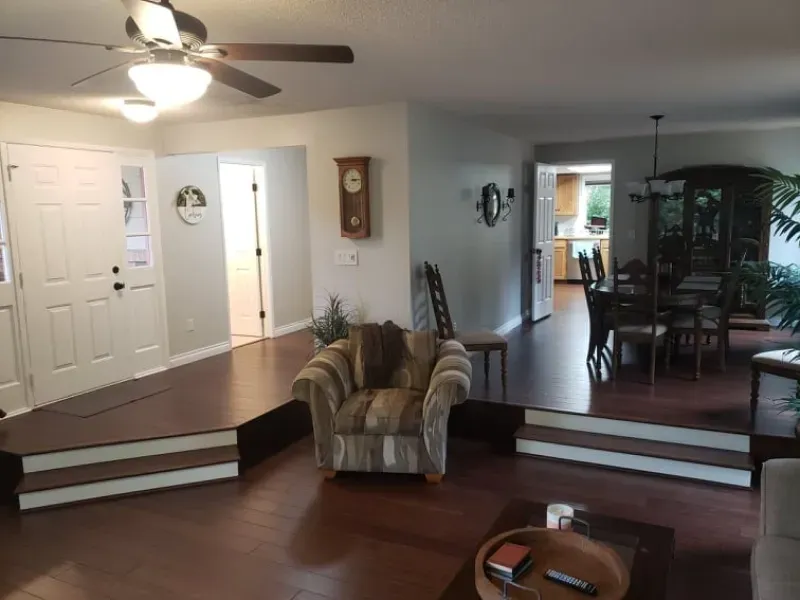 A living room with a chair and a ceiling fan