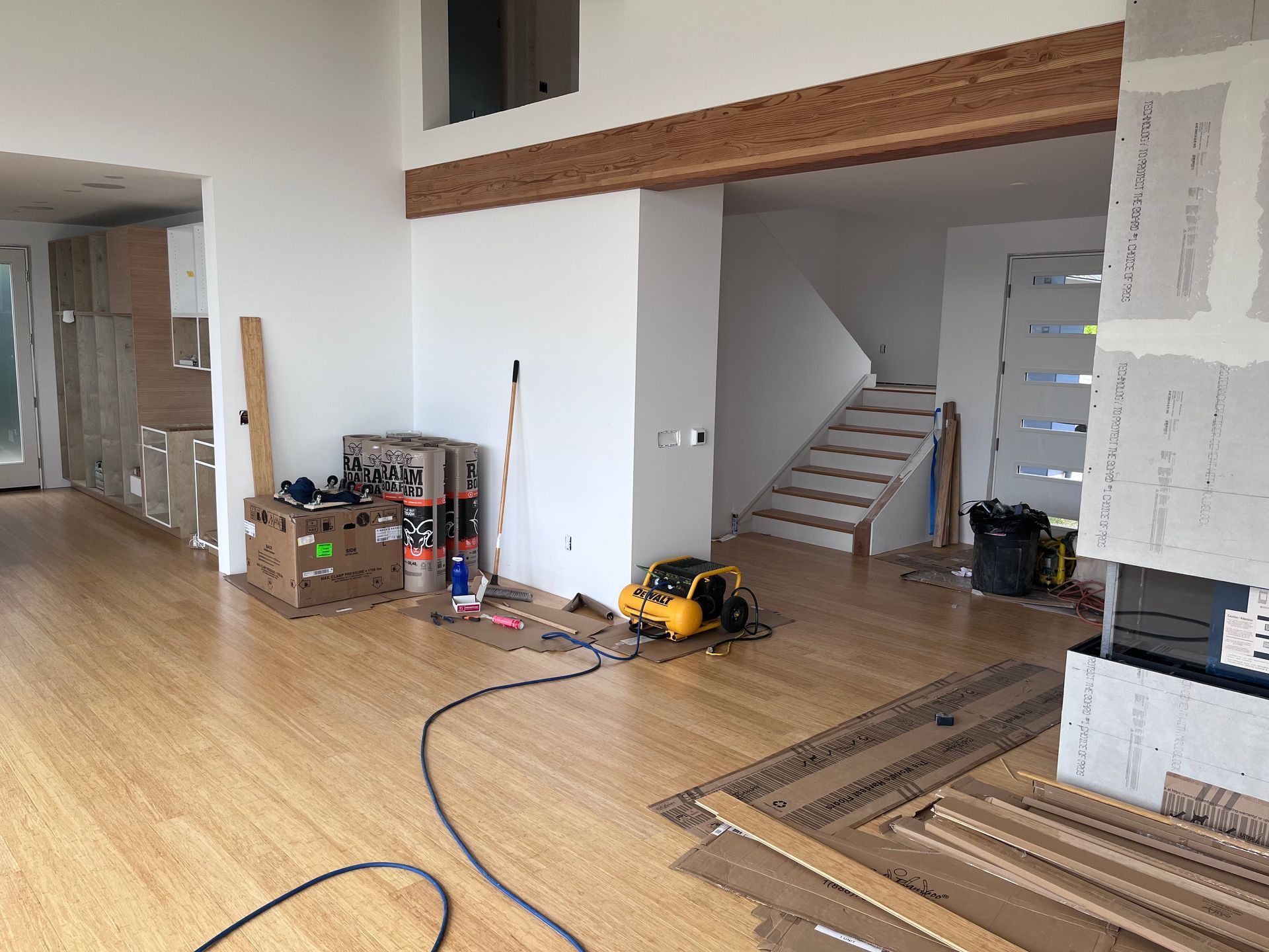 A large room with hardwood floors and a staircase in the background