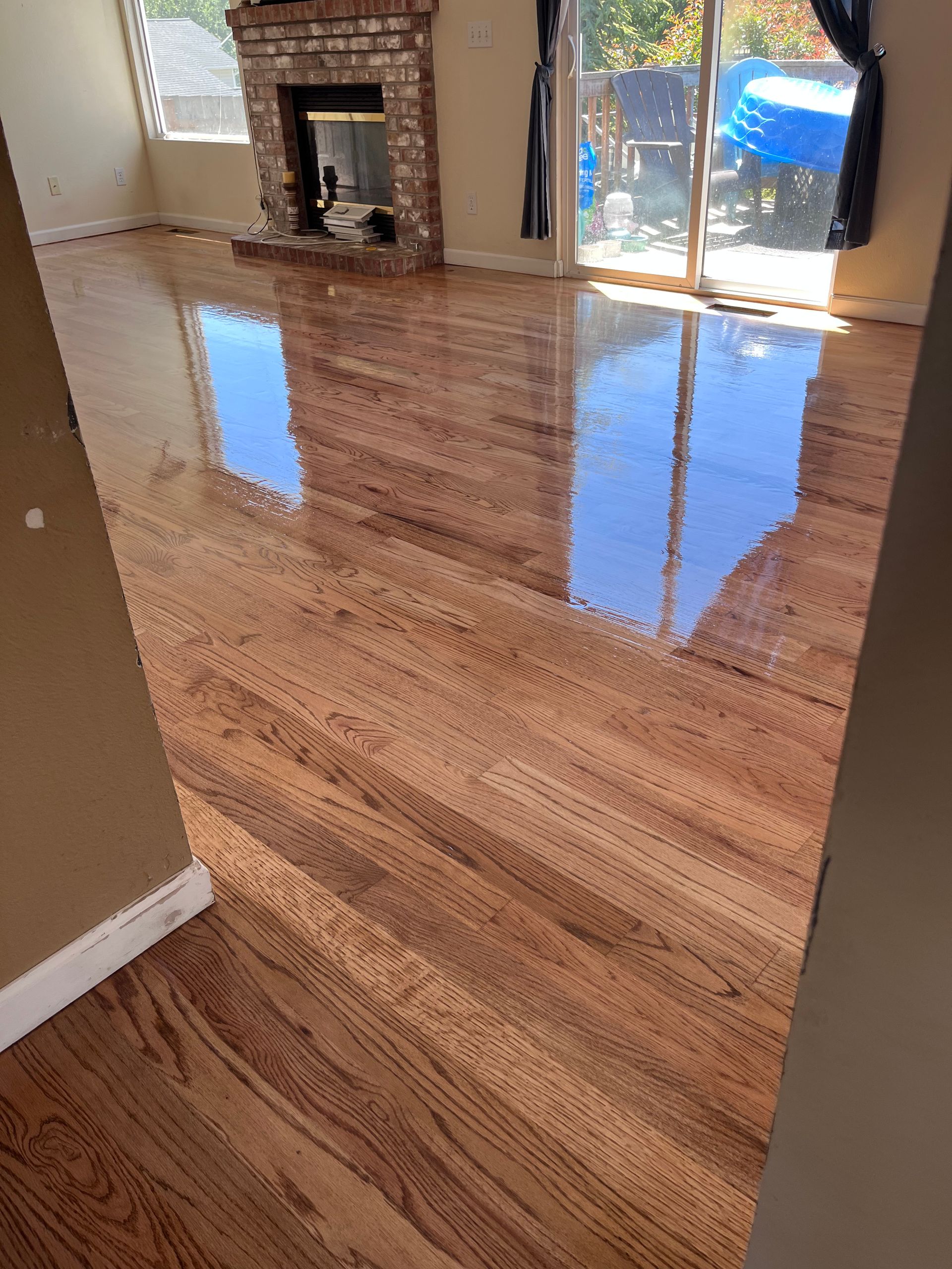 A living room with hardwood floors and a fireplace.