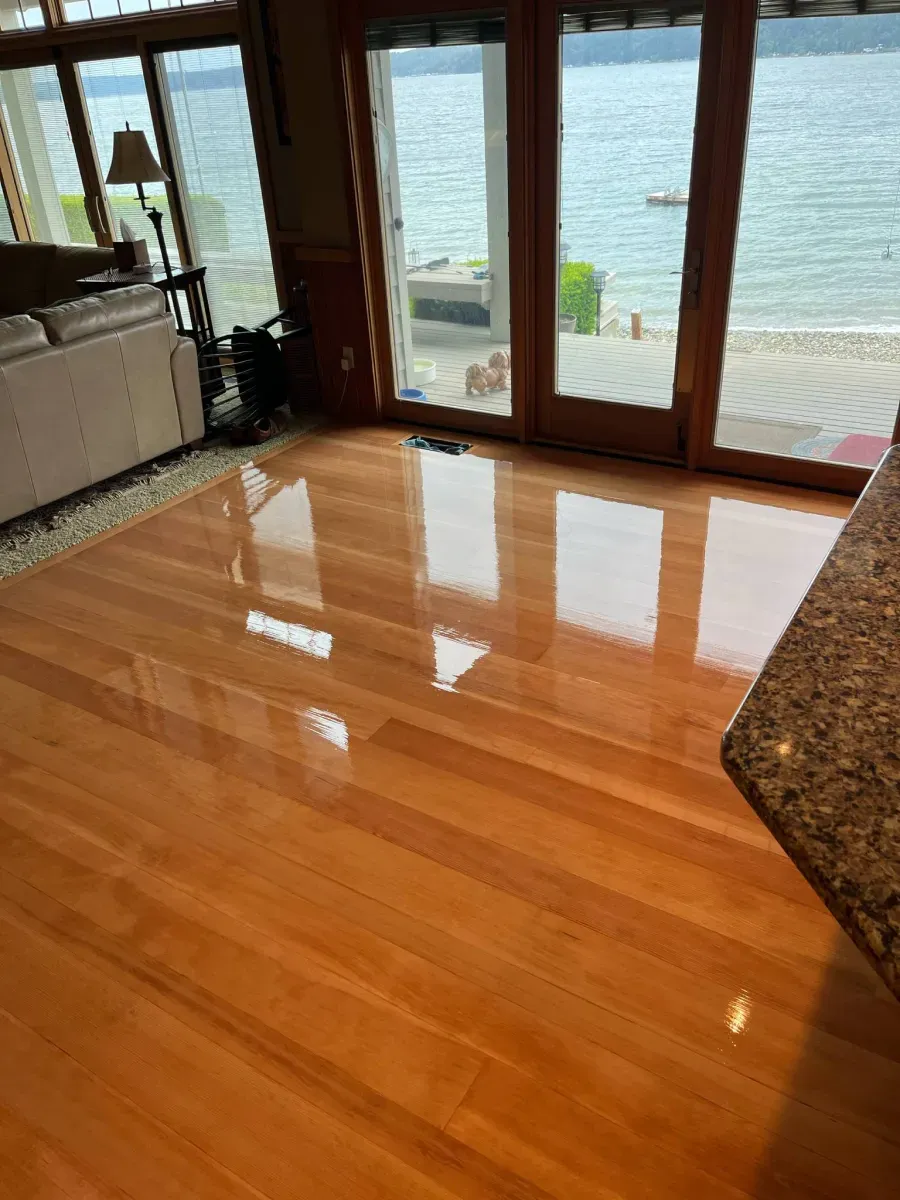 A living room with hardwood floors and a view of the ocean.
