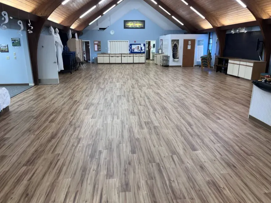 A wooden floor in a room with stairs and a counter.