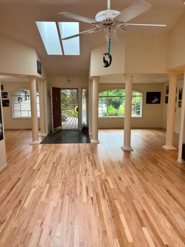 A large room with hardwood floors and a ceiling fan