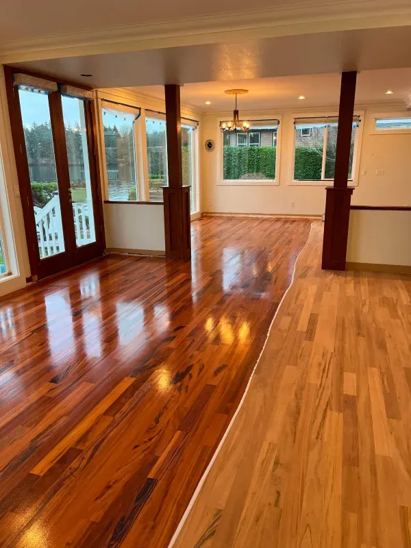 An empty room with hardwood floors and lots of windows