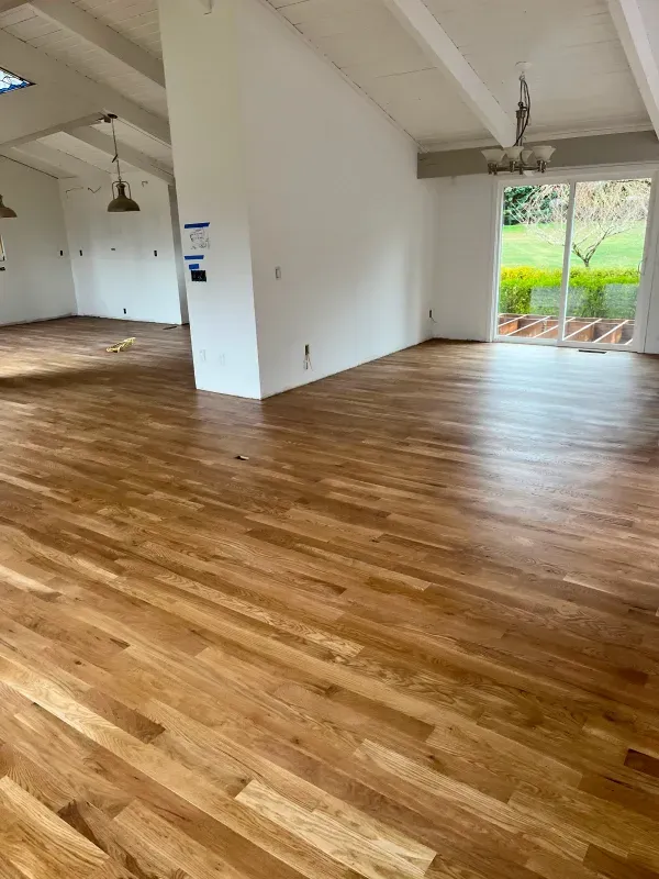 A living room with a wooden floor and white walls.