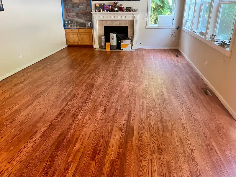 A living room with hardwood floors and a fireplace.