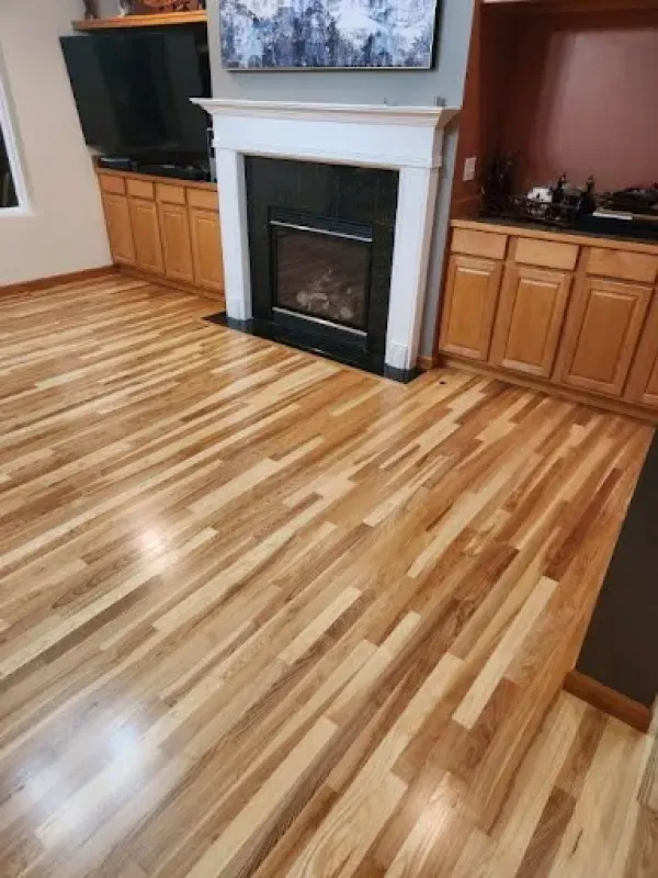 A living room with hardwood floors and a fireplace.