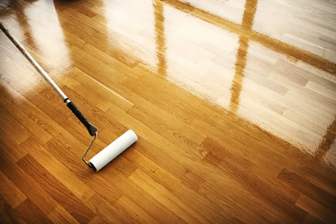 A close up of a wooden floor in a room with two walls.