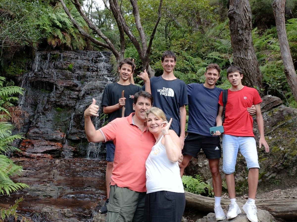 A group of people posing for a picture in front of a waterfall