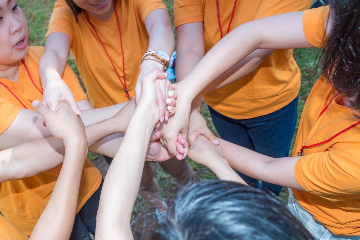 A group of people poses in front of majestic mountains