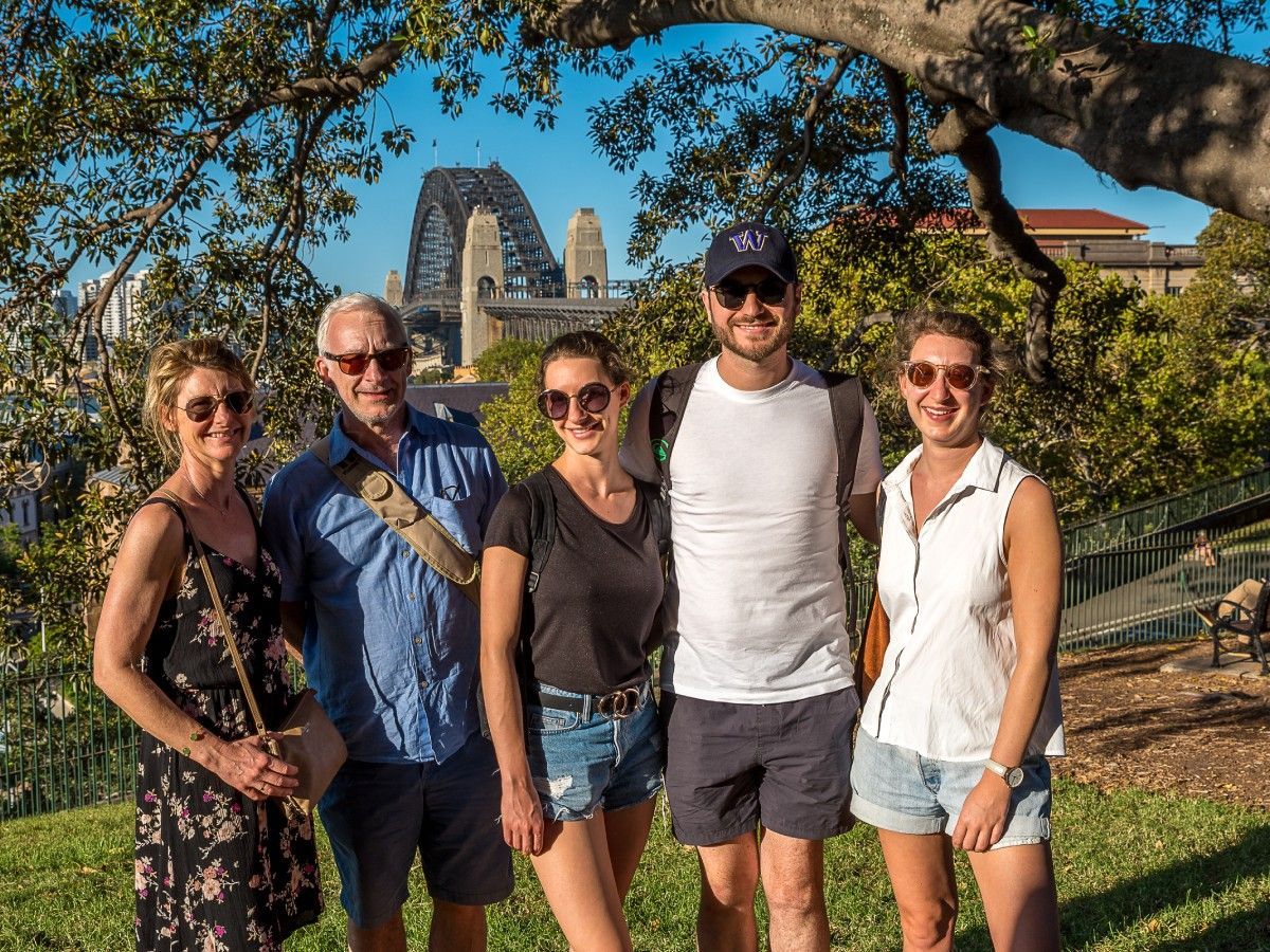 A group of people are posing for a picture in a park.