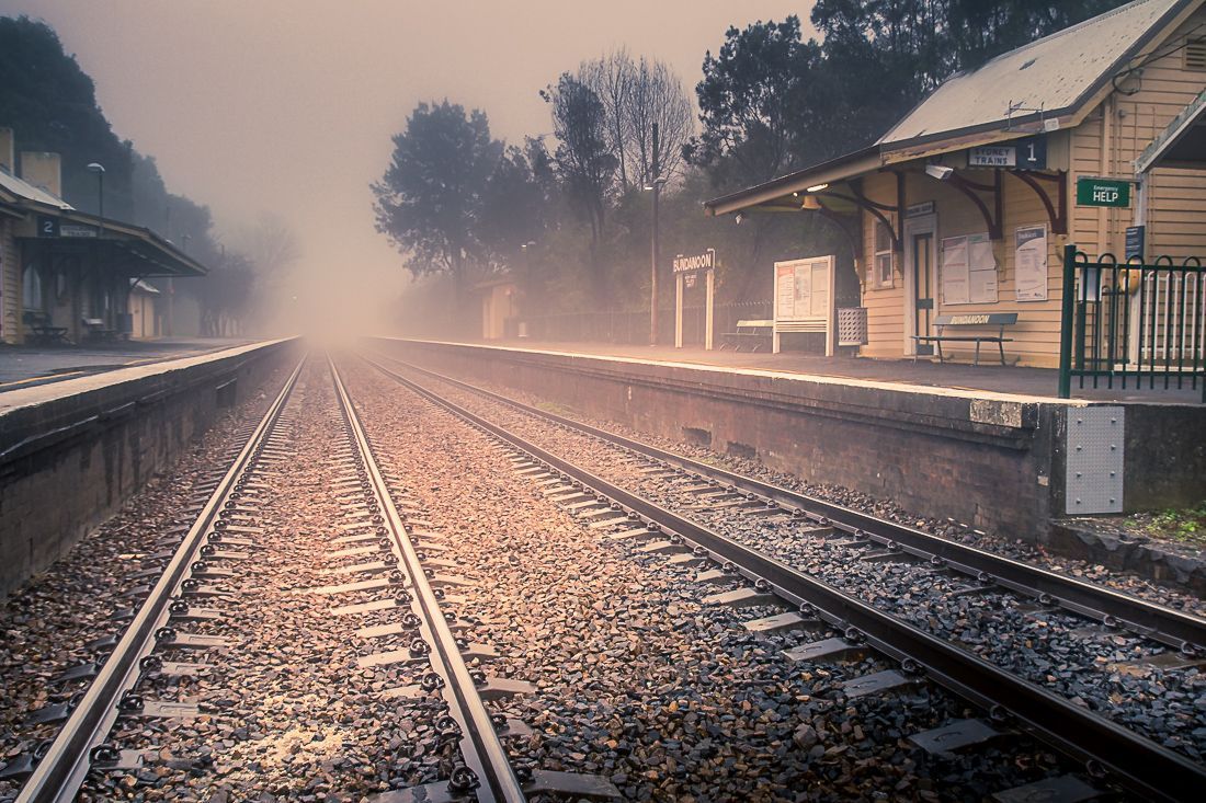 A train station on a foggy day with a train track in the foreground