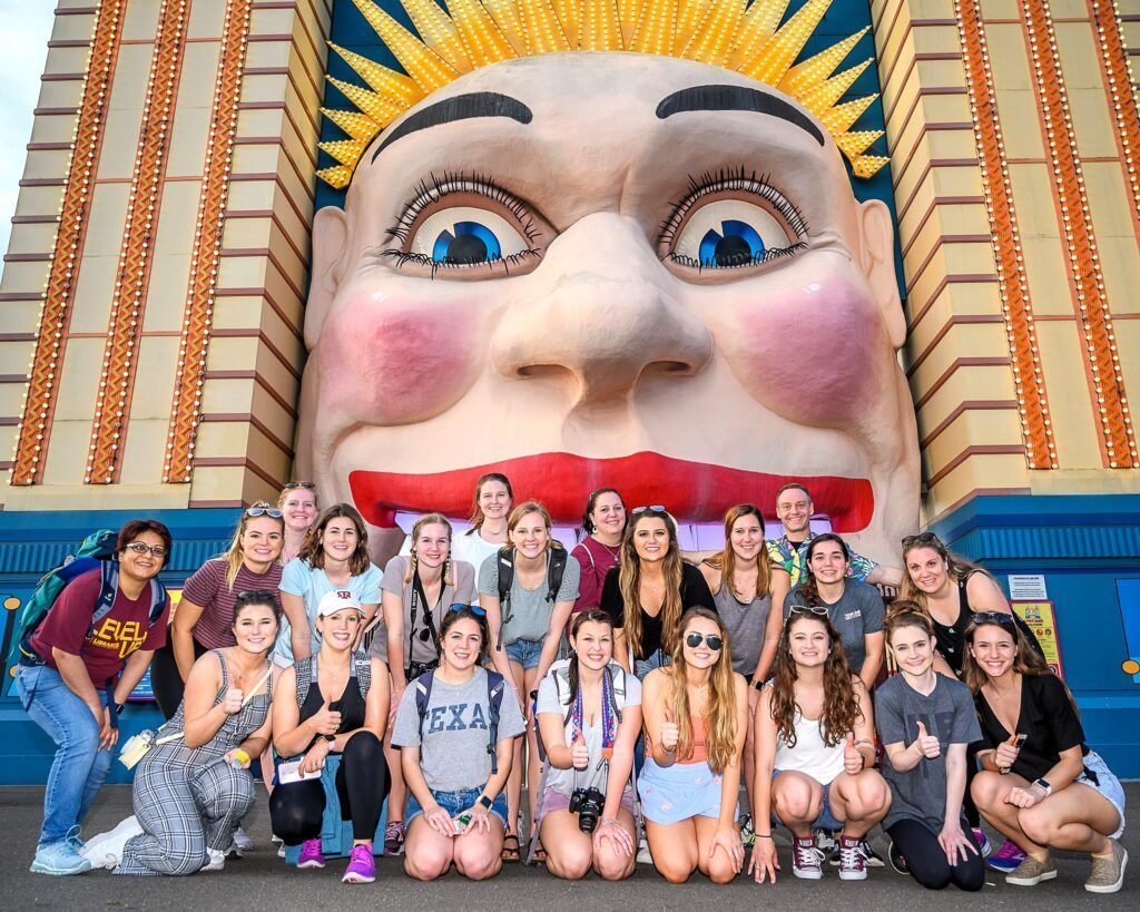 A person holding a camera looks over the valley at sunset