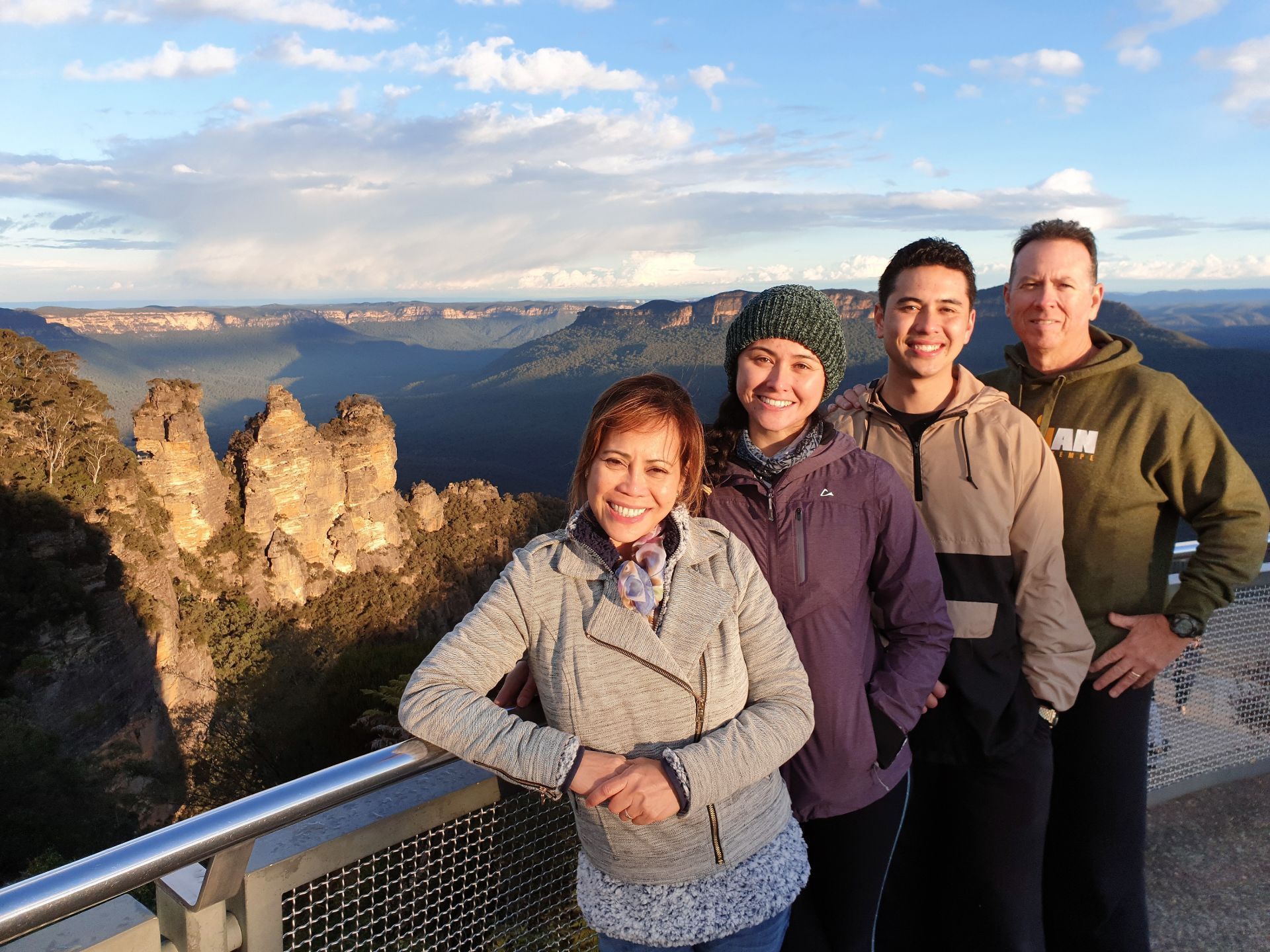 A group of people posing for a picture with mountains in the background
