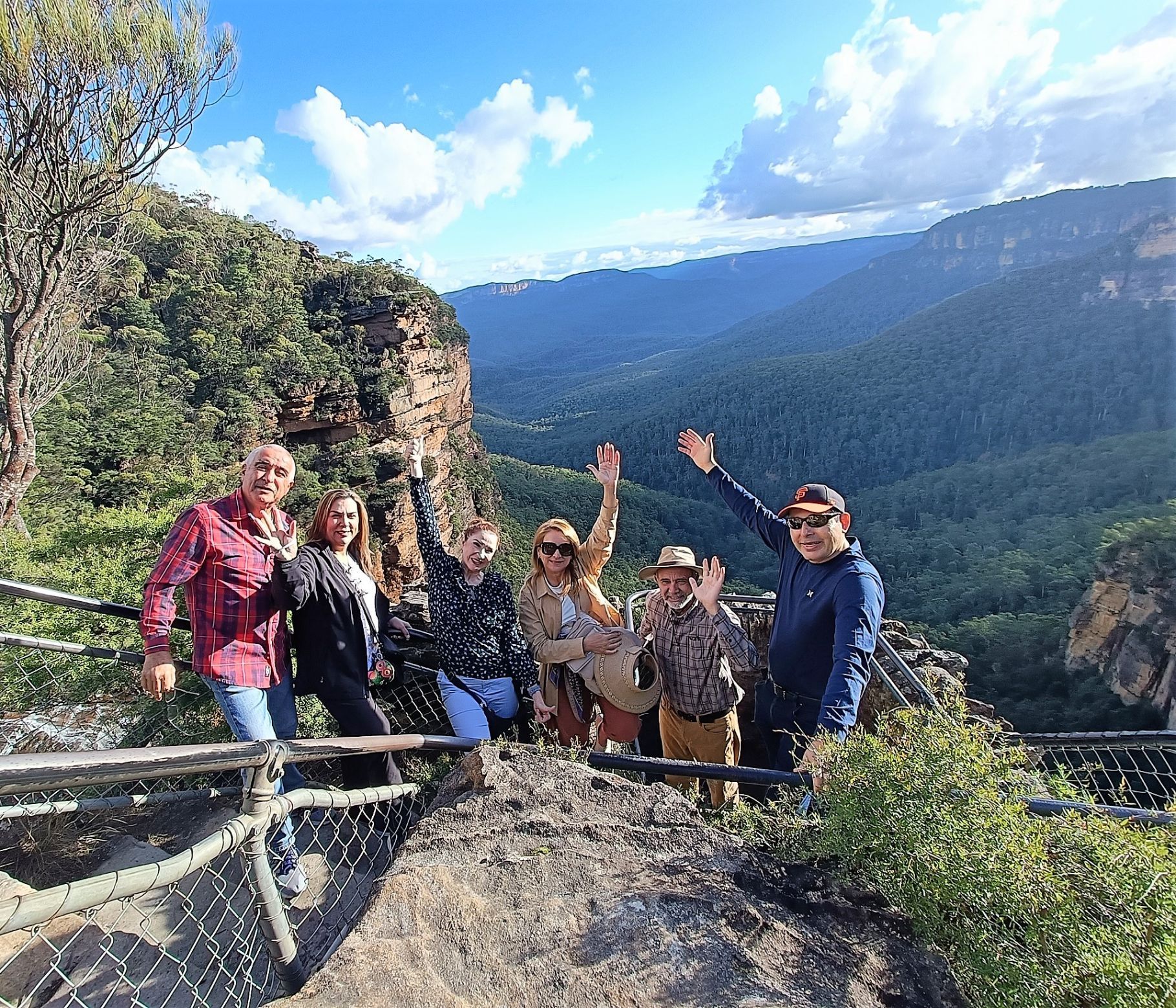 A group of people poses in front of majestic mountains