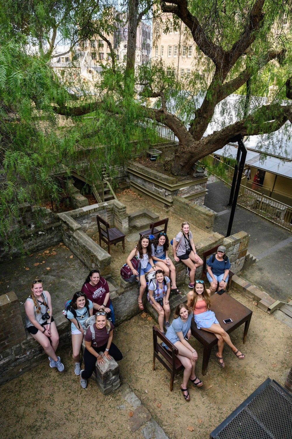 A person holding a camera looks over the valley at sunset