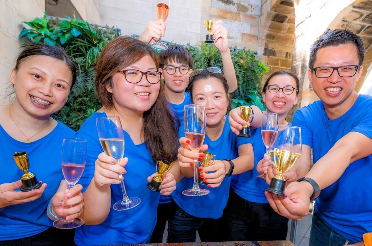 A group of people poses in front of majestic mountains