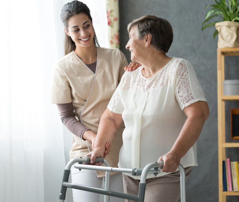 Smiling Beautiful Caregiver And Disabled Old Lady With Walker At Home — iCan Support Services Kawana QLD