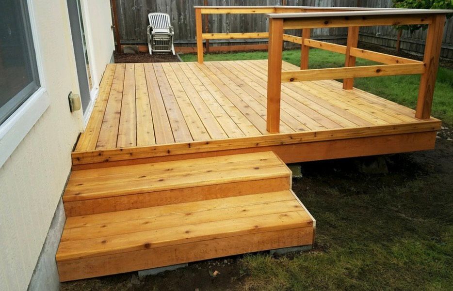 Wooden deck with steps, handrails, and a small yard.