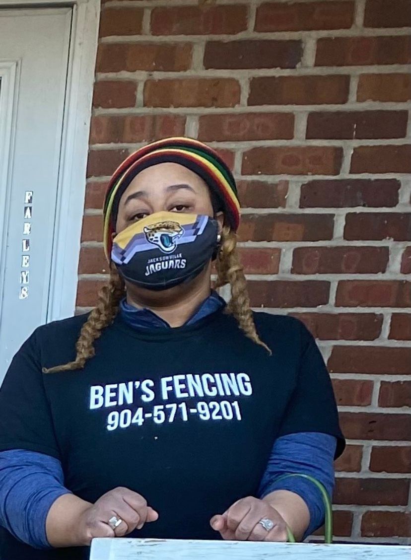 A woman wearing a mask and a ben 's fencing shirt