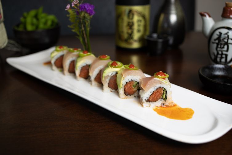 Jalapeno jumper roll on a white plate on a table.