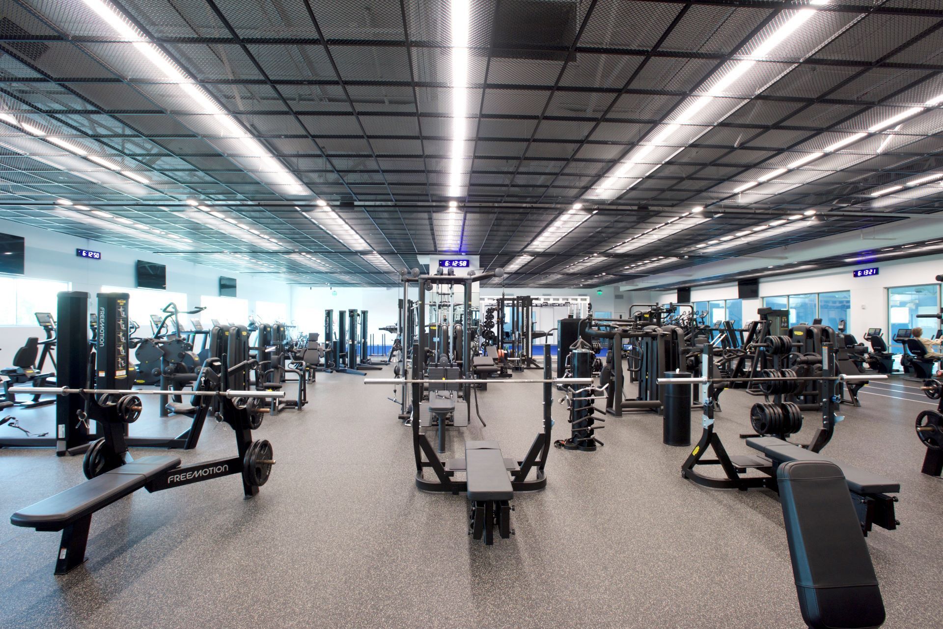 A large gym filled with lots of exercise equipment.