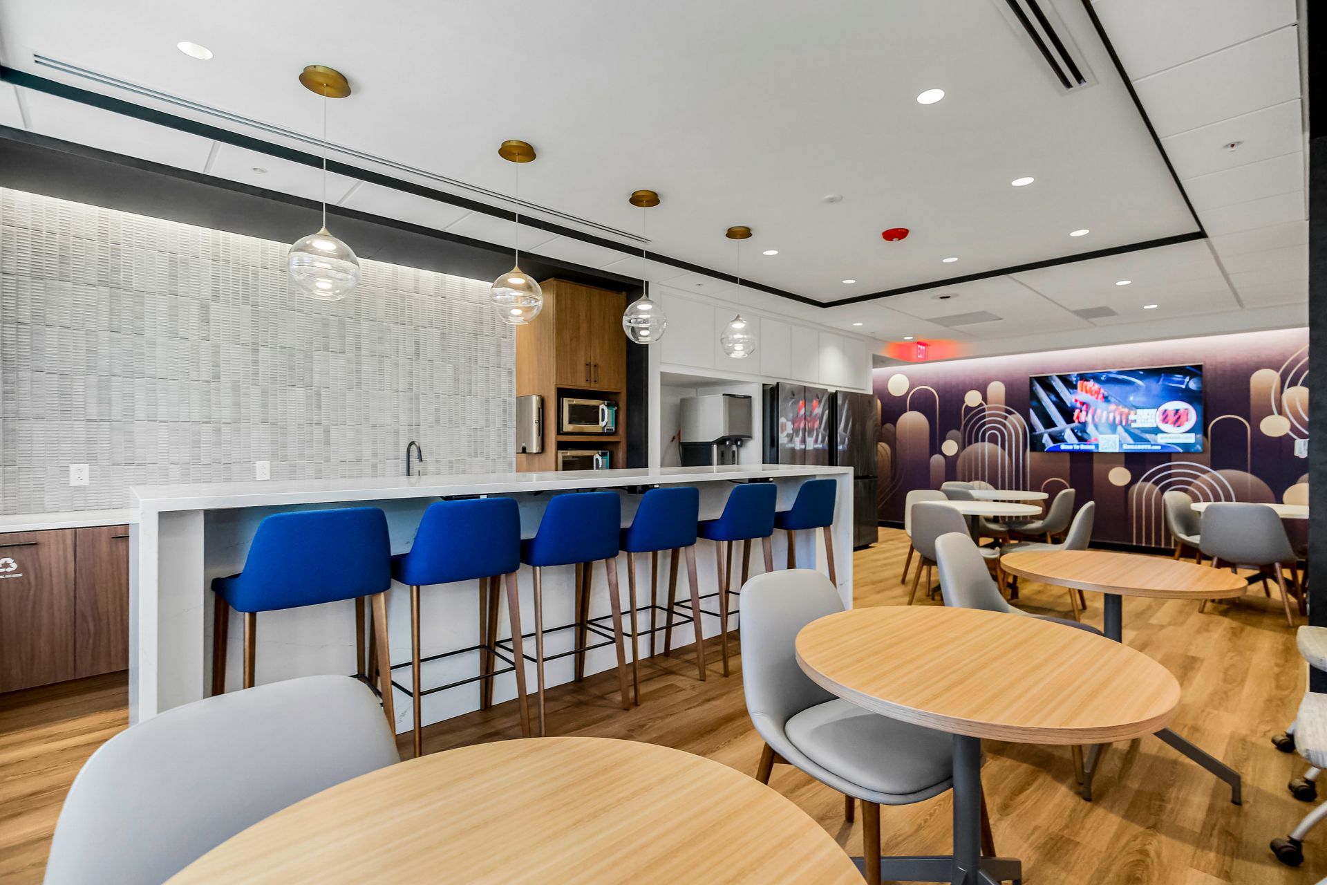 A room with tables and chairs and a bar.