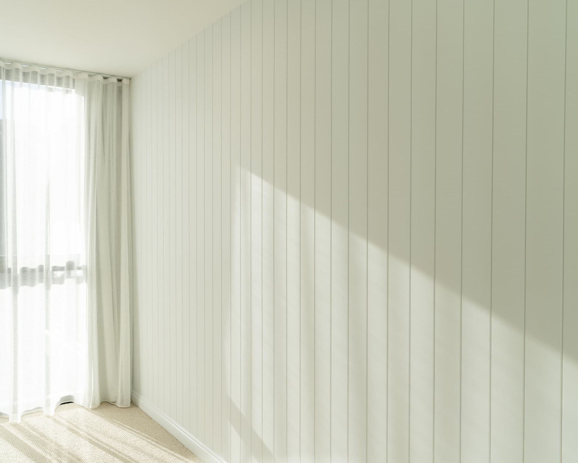 A room with white walls and a large window.