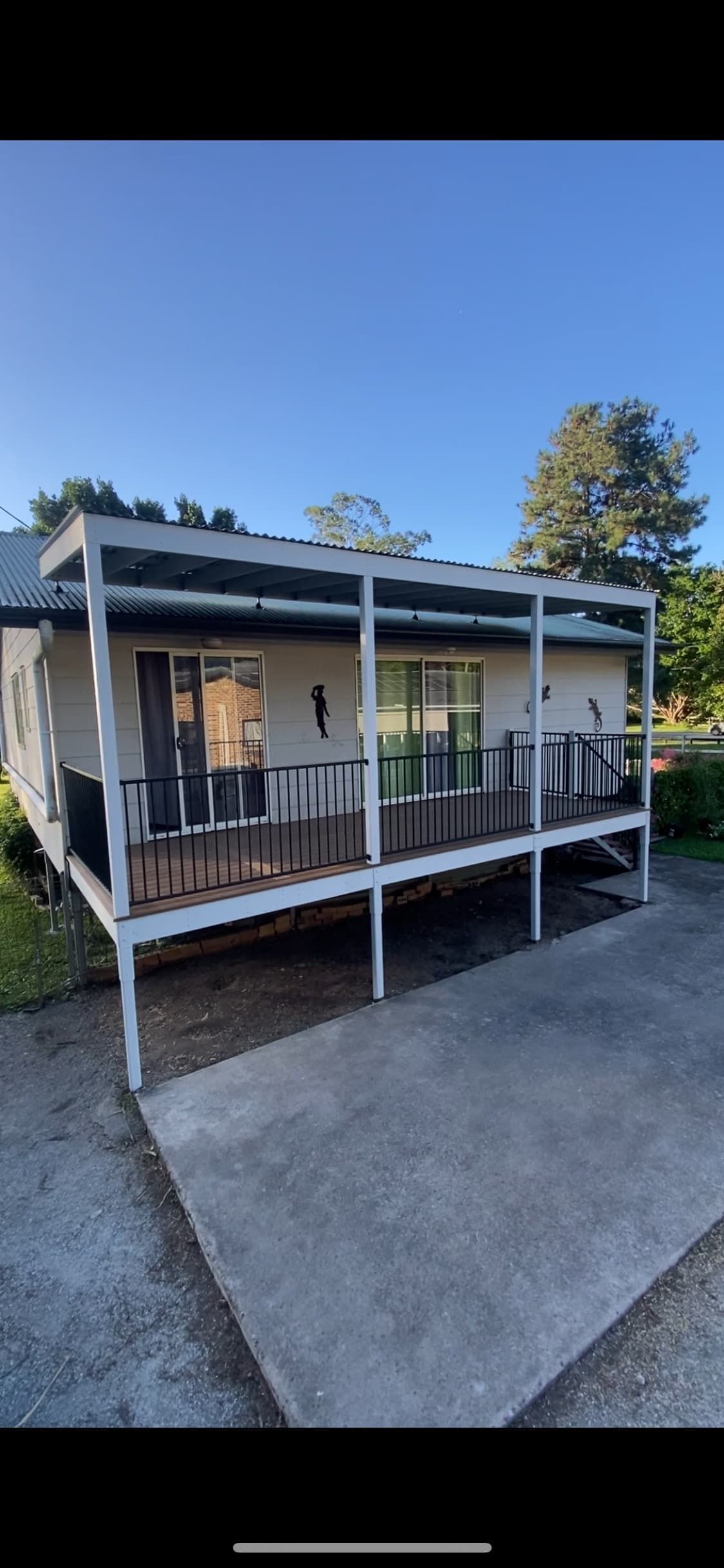 A small white house with a large porch and a patio.
