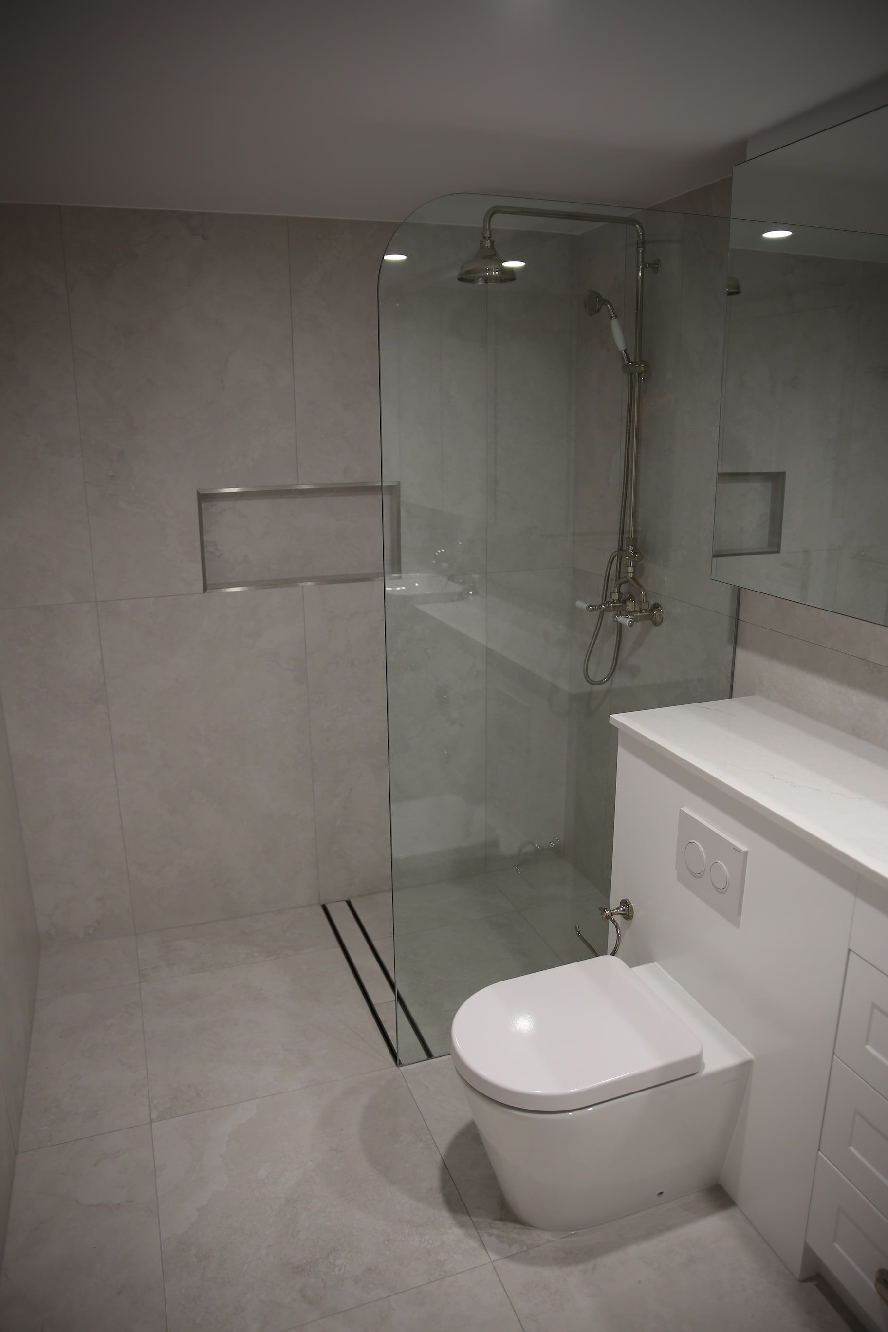 A bathroom with a toilet and a walk in shower.